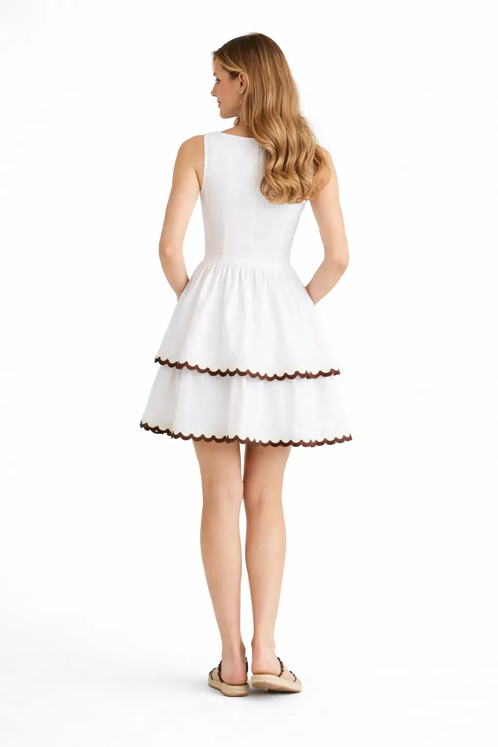 Woman wearing a white dress with brown trim on a white background