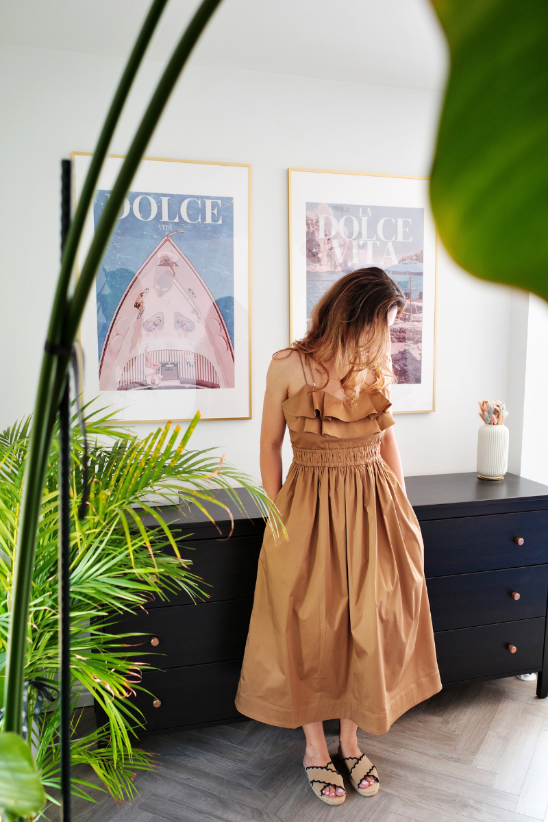 Model wearing a Summer Maxi Dress - Alma in a stylish interior with plants and art prints.